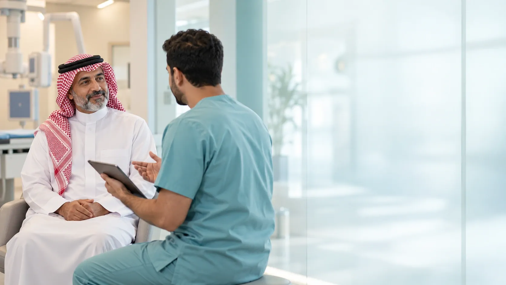 صورة تعبيرية لمراجع سعودي يتحدث مع مختص التصوير الطبي الذي يظهر من الخلف